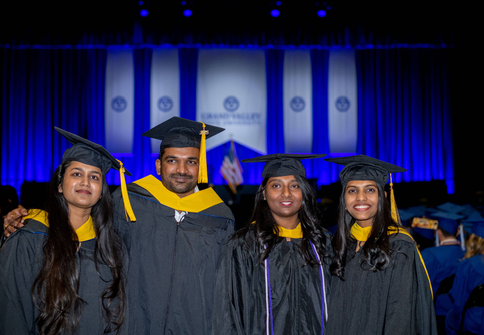 Four students at graduation with black caps and gowns